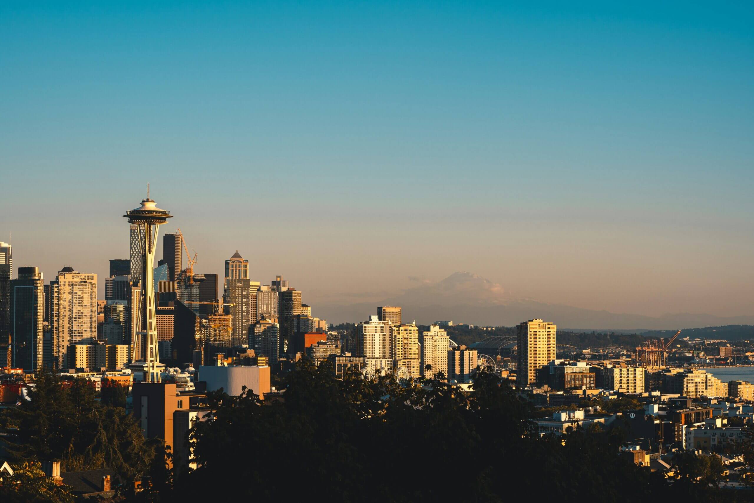 Seattle Space Needle and city skyline at sunset with Mount Rainier for private jet charter scenic flights